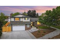 Charming two-story home with brick and siding, manicured lawn, and a two-car garage on a tree filled lot at 15034 E Floyd Ave, Aurora, CO 80014