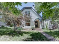 Charming two-story home boasts a light exterior, arched entryway, and small balcony at 1315 Gaylord St, Denver, CO 80206