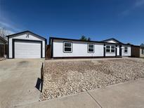 Charming home featuring a detached garage and rock landscaping for easy maintenance at 8362 Jasmine St, Commerce City, CO 80022