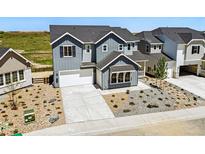 Charming two-story home featuring gray siding, a well-manicured yard, and a spacious driveway and attached garage at 3327 Backdrop Ct, Castle Rock, CO 80108