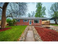 Charming red brick home with well-manicured lawn, blue shutters, and a welcoming walkway at 3200 W Chenango Ave, Englewood, CO 80110