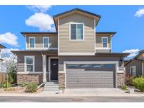 Charming two-story home with neutral siding, stone accents, and a two-car garage on a sunny day at 11235 S Neu Towne Cir, Parker, CO 80134