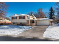 Ranch style home with attached garage and snow-covered yard at 900 Emerald St, Broomfield, CO 80020