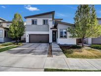 Modern two-story home with two-car garage, concrete driveway, and manicured landscaping at 18085 E 107Th Pl, Commerce City, CO 80022