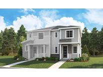 Beautiful new construction townhome with stone accents, green lawn, and covered porch at 1226 Penner Dr, Erie, CO 80026
