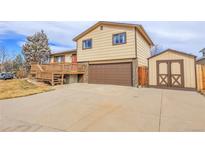 House exterior features a two-car garage and a deck at 9359 W Lake Dr, Littleton, CO 80123