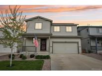 Charming two-story home featuring a covered porch, two-car garage, and well-maintained front yard with mature tree at 1607 Goldfield Trl, Castle Rock, CO 80109