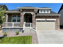 Charming home exterior featuring a stone facade, two-car garage, and landscaped front yard at 737 Raindance St, Erie, CO 80516