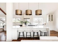 Bright, open kitchen with a large island, pendant lighting, and modern appliances at 3624 S Poplar St, Denver, CO 80237