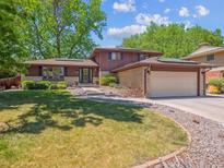 Two-story home featuring an attached garage and a well-maintained front yard with mature trees at 7379 S Lafayette W Cir, Centennial, CO 80122