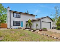 Charming two-story home featuring a well-manicured lawn and a bright blue front door at 3575 S Ouray St, Aurora, CO 80013