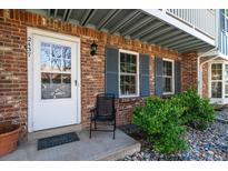 Inviting front door with charming brickwork, gray shutters, and beautiful landscaping adds curb appeal at 2437 E Geddes Pl, Centennial, CO 80122