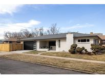 Charming single-story home featuring a modern garage door, manicured front yard, and brick facade at 3501 W 41St Ave, Denver, CO 80211