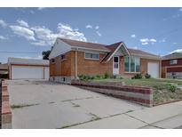 Charming single-story brick home featuring an inviting front yard and a detached two-car garage at 10900 Mildred Dr, Northglenn, CO 80233