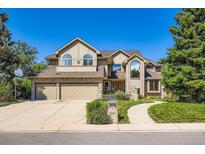 Beautiful two-story home with a three-car garage, arched windows, and a well-manicured lawn at 9096 E Colorado Cir, Denver, CO 80231
