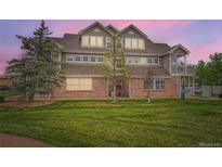 Charming multi-story brick townhome featuring manicured lawn, mature trees, and private balcony at 16320 E Fremont Ave # 1, Aurora, CO 80016