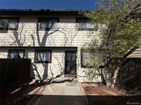 Townhouse with a front door, and fenced in yard with a tree in front of the home at 12010 E Harvard Ave, Aurora, CO 80014