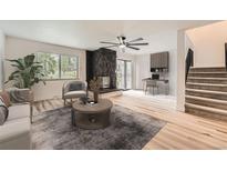 Light-filled living room featuring a unique fireplace, modern ceiling fan, and neutral decor at 12010 E Harvard Ave, Aurora, CO 80014