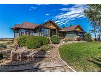 Charming two-story home with green siding, a landscaped yard, and beautiful, blue sky at 1505 Legacy Trl, Elizabeth, CO 80107