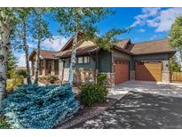 Craftsman-style home featuring a stone facade, a three-car garage, and tasteful landscaping at 1505 Legacy Trl, Elizabeth, CO 80107