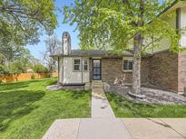 Charming brick home featuring a well-manicured lawn and mature tree at 1720 S Ammons St # A, Lakewood, CO 80232