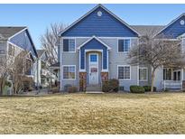 Charming townhome featuring a blue and gray exterior and a well-maintained front yard at 12941 Lafayette St # E, Thornton, CO 80241