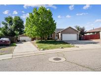 Charming single-Gathering home with lush green lawn, mature tree, and long driveway at 1115 Cherry Ct, Fort Lupton, CO 80621
