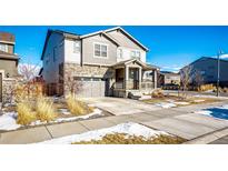 Charming home featuring a stone facade, covered porch, and attached garage at 24505 E Ada Pl, Aurora, CO 80018