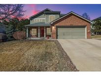 Inviting two-story home with a brick facade, attached garage and covered front porch at 10795 Quail Creek E Dr, Parker, CO 80138