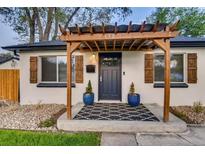 Charming home featuring a pergola over the entry way, stylish shutters, and a welcoming black and white patterned rug at 150 S Osceola St, Denver, CO 80219