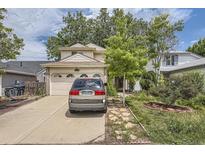 Two-story home featuring an attached two-car garage, a long driveway, mature shade trees and manicured landscaping at 2370 Redwood Ave, Lafayette, CO 80026
