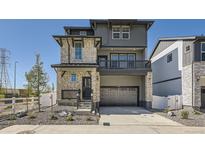 Modern two-story home with a stone and gray facade, covered porch and a two car garage at 2190 S Haleyville Way, Aurora, CO 80018