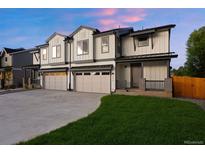Modern townhome boasts neutral paint, two-car garage and grassy front lawn at 4030 Upham St, Wheat Ridge, CO 80033