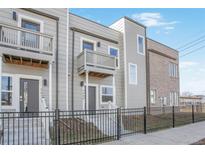 Charming two-story townhome with a front-facing balcony and wrought iron fencing at 3480 W 14Th Ave, Denver, CO 80204