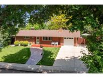 Charming red brick home with a manicured lawn, front porch, and a spacious driveway at 1040 Zang St, Golden, CO 80401