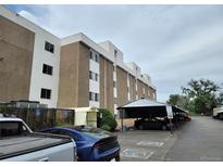 Apartment complex exterior featuring covered parking and handicap parking spaces on a cloudy day at 384 S Ironton St # 407, Aurora, CO 80012