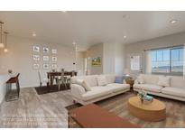 Bright living room and dining area featuring hardwood floors, comfortable seating, and abundant natural light at 862 W 129Th Pl, Westminster, CO 80234