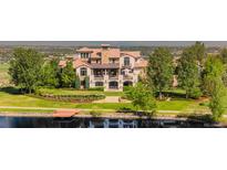 Luxury home featuring lush landscaping, a dock, and expansive lawn overlooking a serene lake at 1820 Mallard Dr, Broomfield, CO 80020