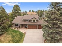 Charming two-story home featuring a three-car garage, mature trees, and a well-maintained front yard at 8015 Lt William Clark Rd, Parker, CO 80134