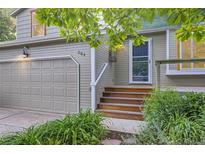 Inviting home entrance features wooden steps, a storm door, and a well-maintained front yard with lush greenery at 284 S Lincoln Ave, Louisville, CO 80027