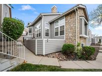 Inviting condo exterior boasts stone accents, gray siding, and well-maintained landscaping at 6848 Zenobia St # 9, Westminster, CO 80030