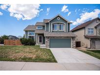 Charming two-story home featuring a well-maintained lawn, a stone-accented facade, and an attached two-car garage at 5479 Lost Meadow Trl, Castle Rock, CO 80104