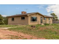 Charming single-story home with a well-maintained lawn and mature trees offering a serene and private setting at 19855 Draco Dr, Monument, CO 80132