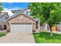 Charming two-story home featuring a brick facade, a two-car garage, and a well-manicured front yard at 7472 S Memphis St, Aurora, CO 80016