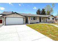 Charming single-story home featuring a well-manicured lawn, long driveway, and two-car garage at 375 Kendall St, Lakewood, CO 80226