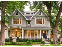 Charming two-story home with gray shingles, black fence, manicured landscaping, and welcoming front porch at 2130 S Milwaukee St, Denver, CO 80210