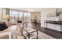 Bright living room with hardwood floors, a stylish rug, and floor to ceiling windows with balcony access at 955 Eudora St # 407E, Denver, CO 80220