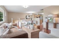 Inviting living room featuring hardwood floors, neutral walls, and an open floor plan with a view into the kitchen at 30321 Chestnut Dr, Evergreen, CO 80439