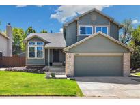 Charming two-story home with a manicured front yard and a welcoming two-car garage at 9494 Devonshire Pl, Highlands Ranch, CO 80126