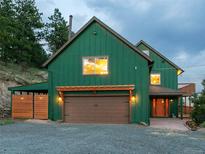 Charming green two-story home with a gravel driveway and a covered garage at 6066 Crawford Gulch Rd, Golden, CO 80403